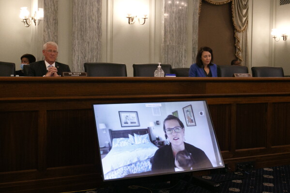 Rebecca Slaughter, Federal Trade Commissioner, holds her newborn daughter Hattie, as she testifies via video conference during a Senate committee hearing in 2020. (AP Photo/Jacquelyn Martin)