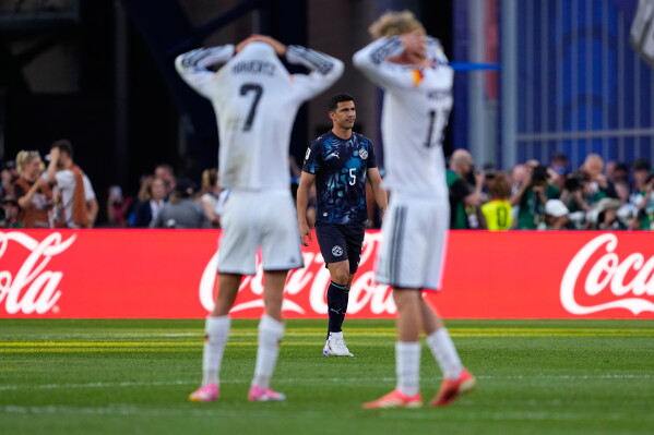 Paraguay's Fabian Balbuena (5) looks on as German players react during a penalty shootout at the end of during the World Cup round of 32 soccer match between Germany and Paraguay in Foxborough, Mass., near Boston, Monday, June 29, 2026. (AP Photo/Petr David Josek)