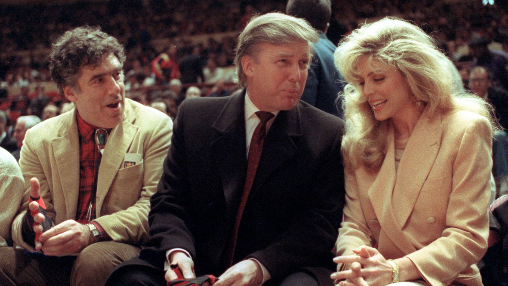 FILE - Actor Elliott Gould joins Donald Trump and Marla Maples at courtside during an NBA basketball game between the Phoenix Suns and the New York Knicks, March 6, 1991.