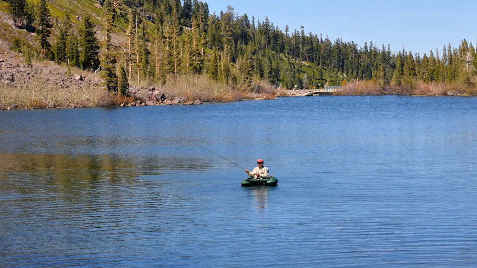 Fisherman in a fishing float tube casting line into Twin Lakes near Mammoth Lakes, California