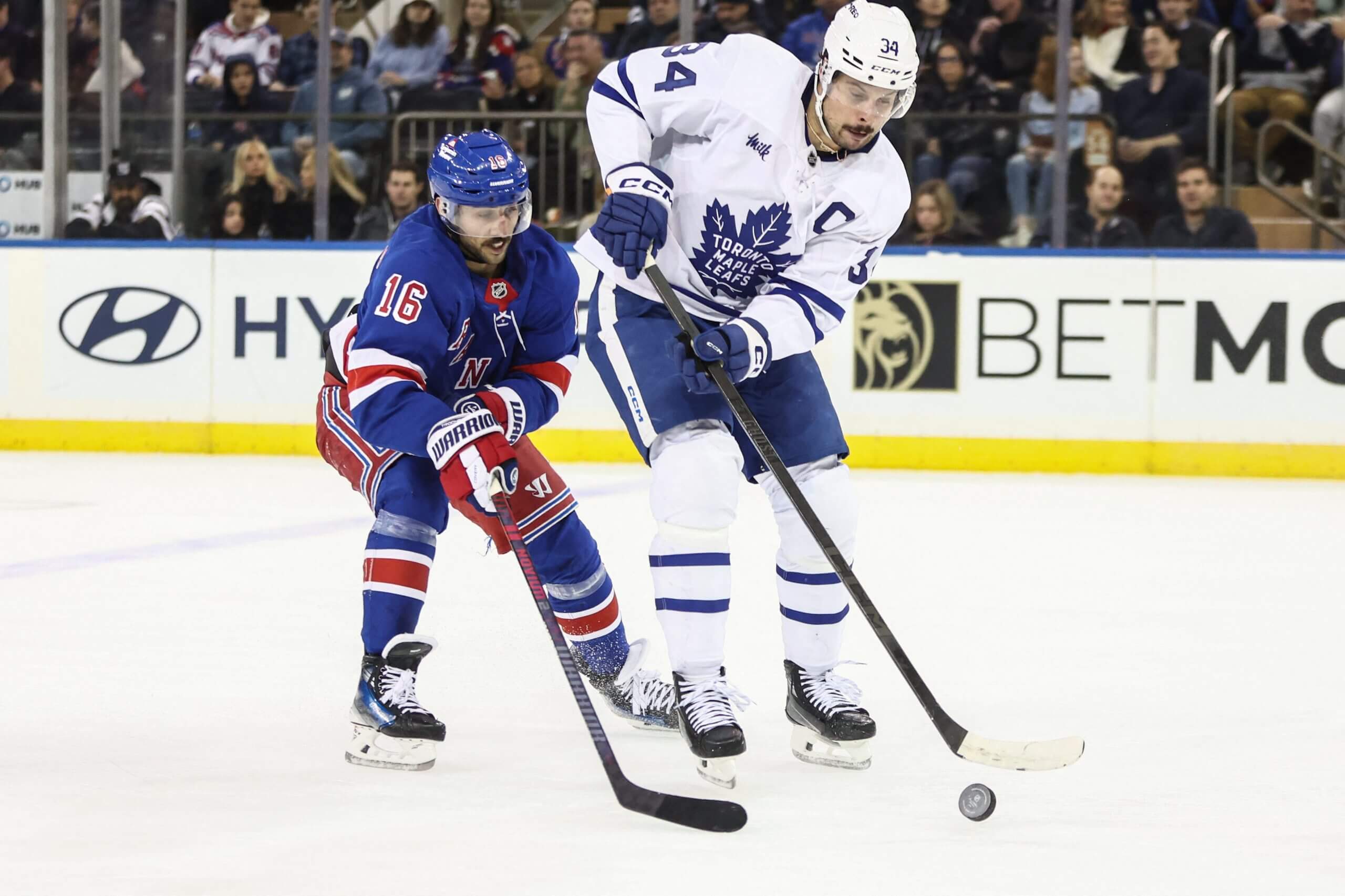 The Rangers' Vincent Trocheck tries to steal the puck from the Maple Leafs' Auston Matthews.
