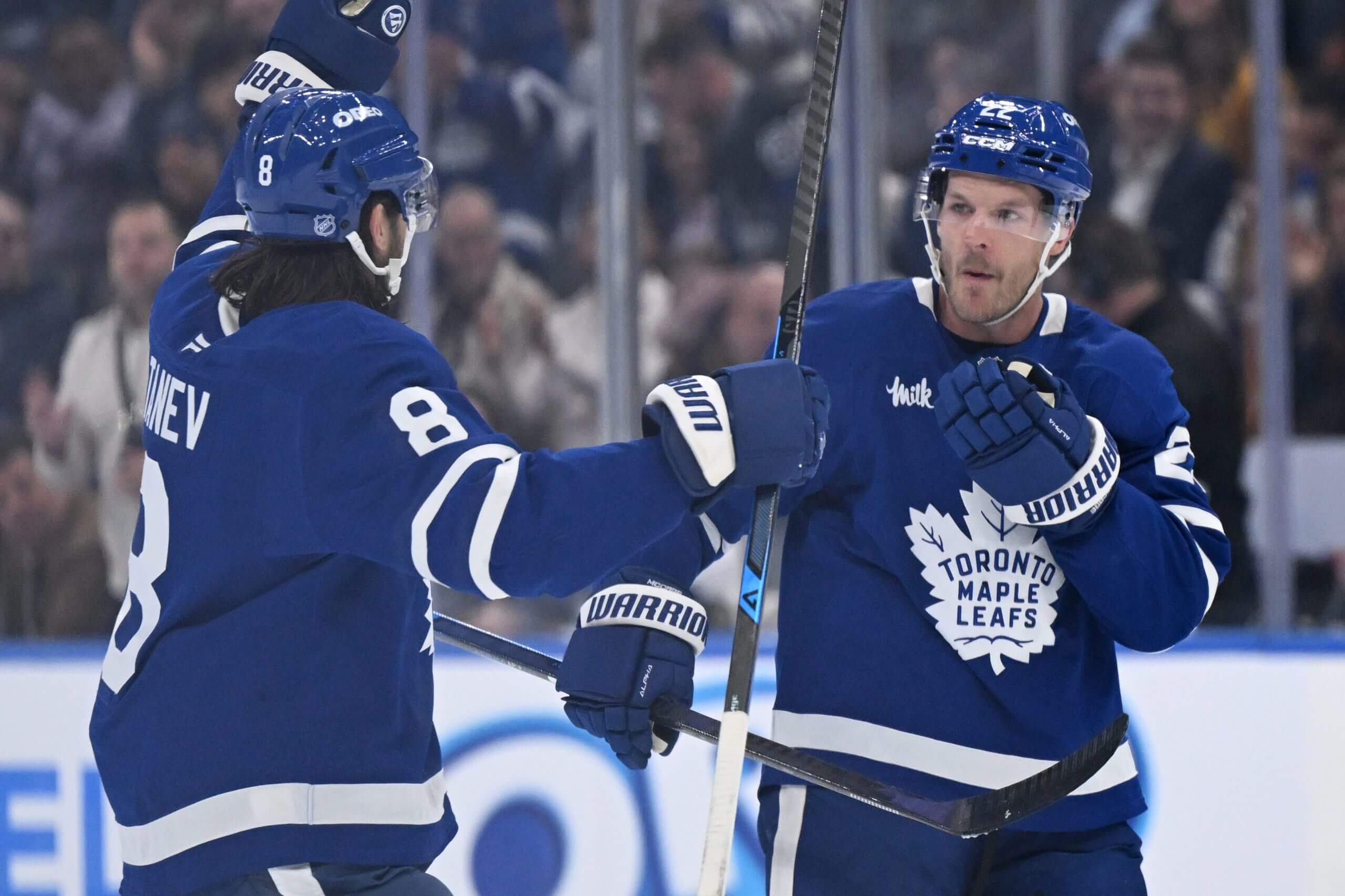 Chris Tanev and Jake McCabe celebrate after a Leafs goal.