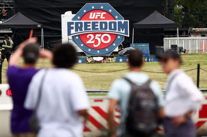 People look at a sign of the UFC Freedom 250 fight card, near the White House in Washington, DC, US, June 9, 2026.