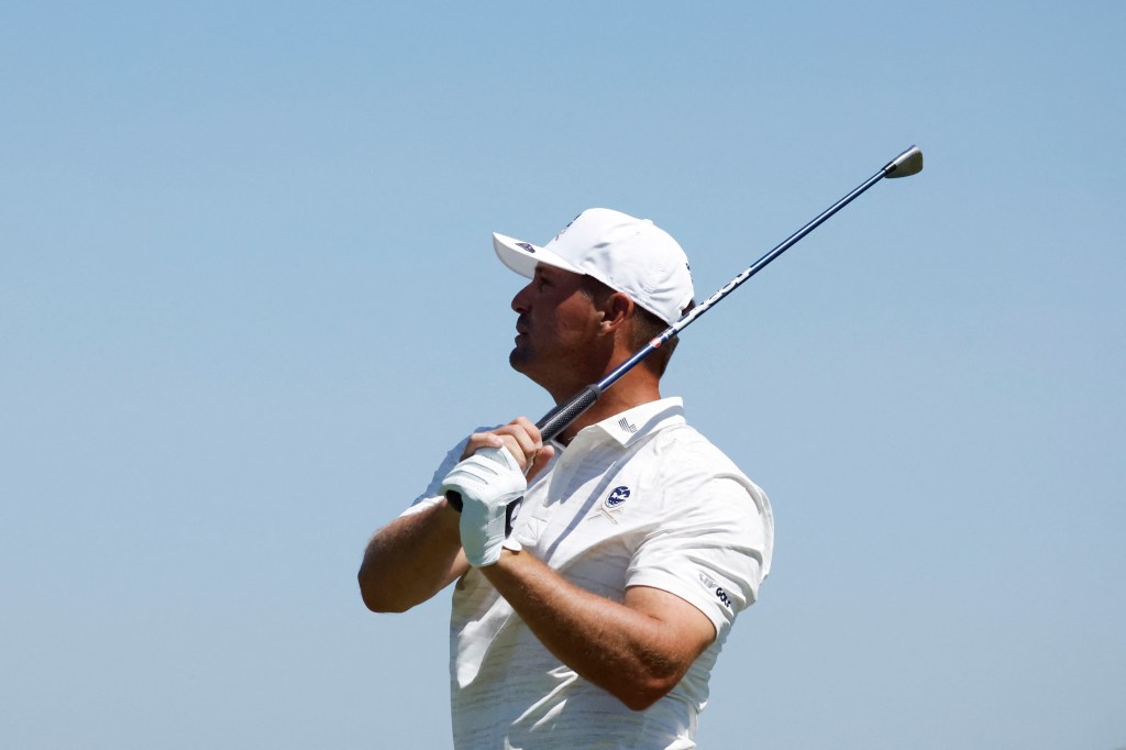 Bryson DeChambeau holding a golf club and looking into the distance during the second round of LIV Golf Andalucia.