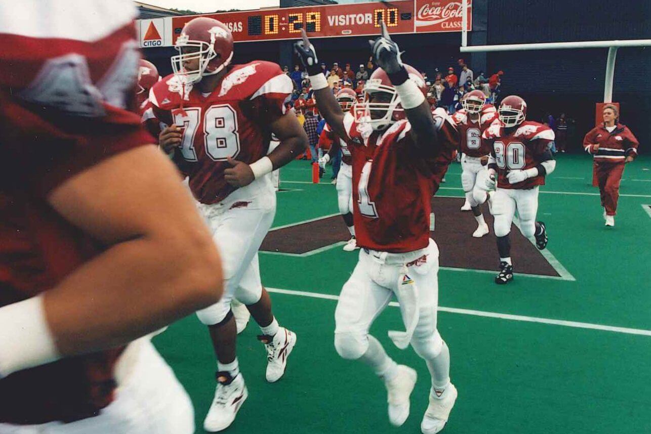 Arkansas football players run out of the tunnel before a 1994 game.