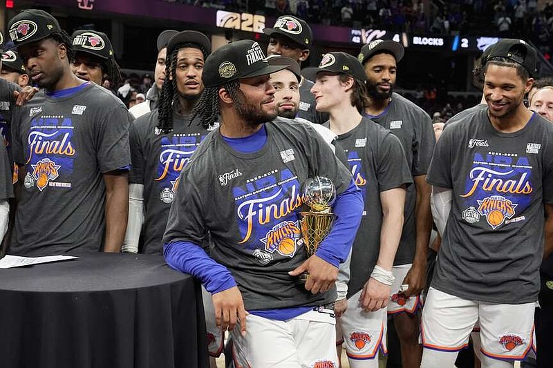 New York Knicks guard Jalen Brunson, center, holds the MVP trophy after Game 4 in the Eastern Conference finals NBA basketball playoffs series against the Cleveland Cavaliers in Cleveland, Monday, May 25, 2026. (AP Photo/Sue Ogrocki)