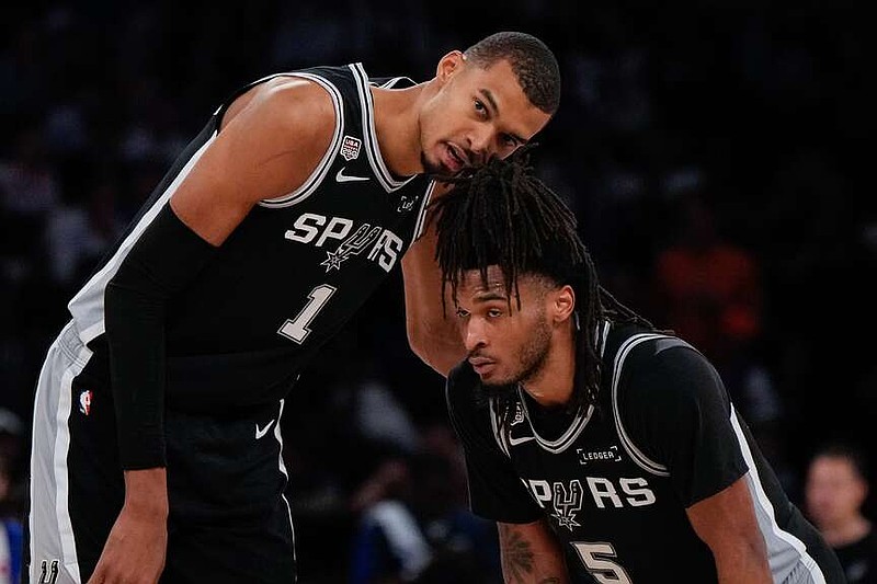 San Antonio Spurs forward Victor Wembanyama (1) talks with guard Stephon Castle during second half of Game 3 of the NBA Finals basketball series against the New York Knicks, Monday, June 8, 2026, in New York. (AP Photo/Ross D. Franklin)