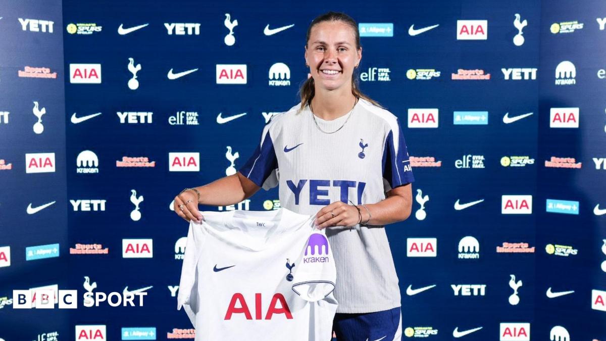Victoria Pelova faces the camera while holding a Tottenham shirt
