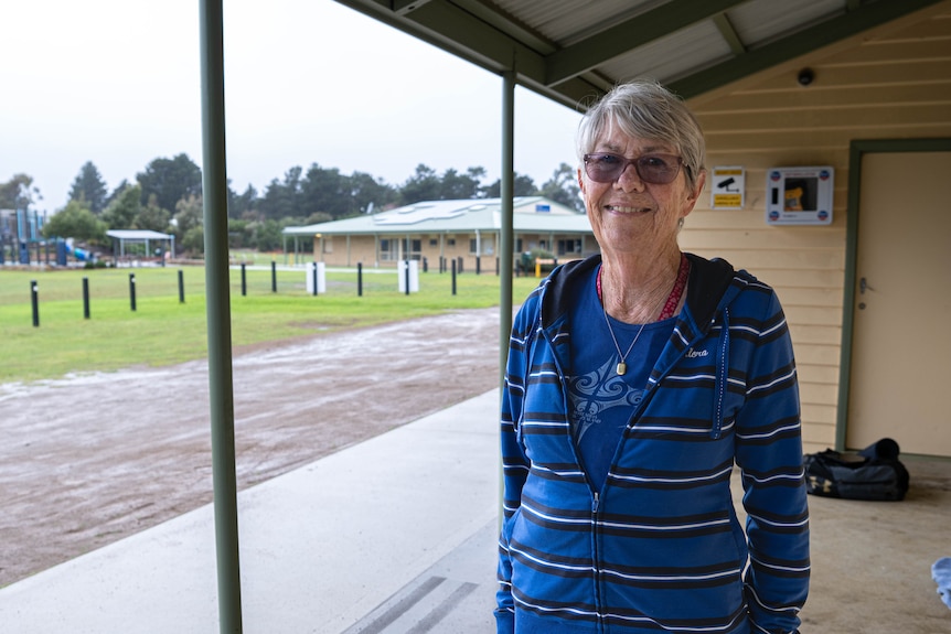 Woman standing under an awning next to a park.