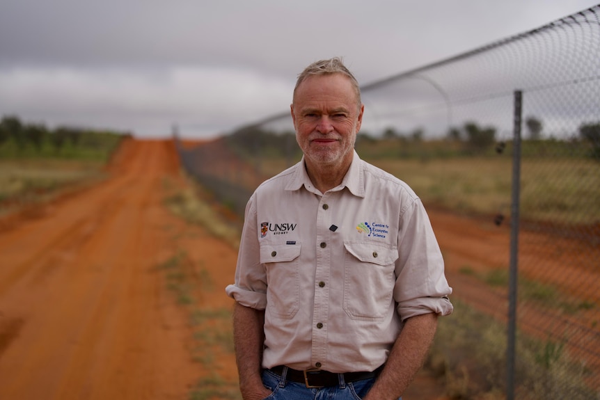 Professor Richard Kingsford stands in front of a pest free enclosure fence.