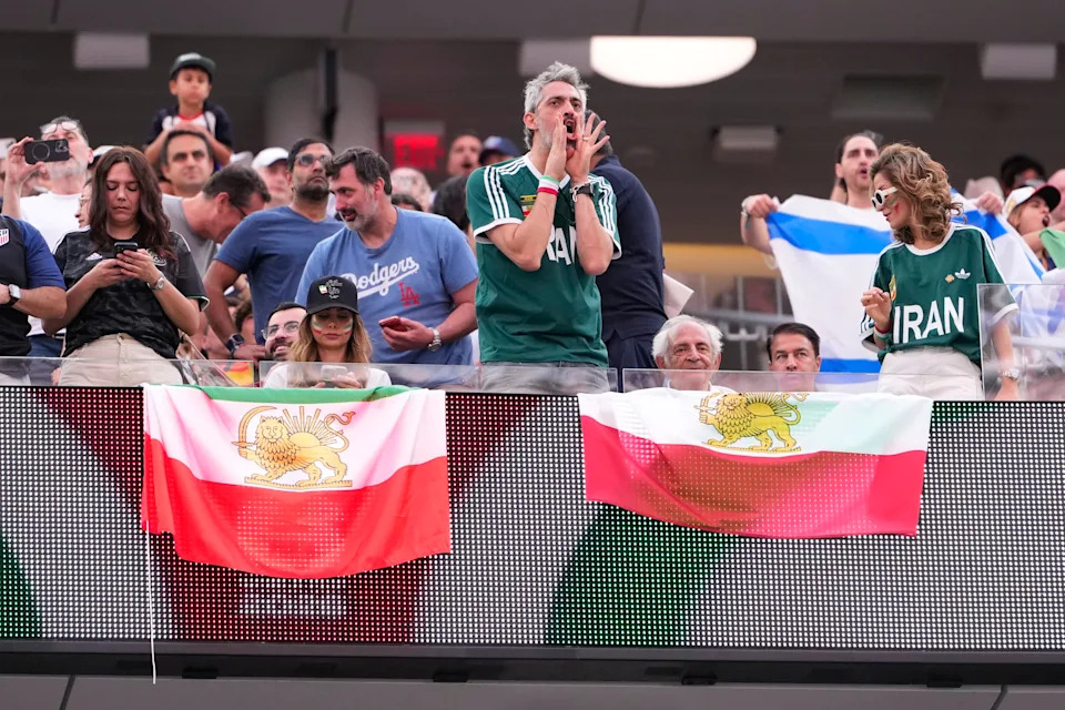 An attendee boos during the National Anthem as others hold the pre-revolutionary flag before the World Cup Group G soccer match between Iran and New Zealand in Inglewood, Calif., near Los Angeles, Monday, June 15, 2026. (AP Photo/Mark J. Terrill)