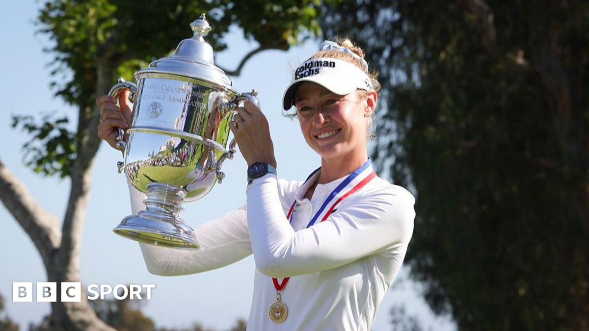 Nelly Korda, wearing a long-sleeved white top and white visor and with a gold medal on a red, white and blue ribbon around her neck, smiles and poses with the silver trophy, holding it up to her right