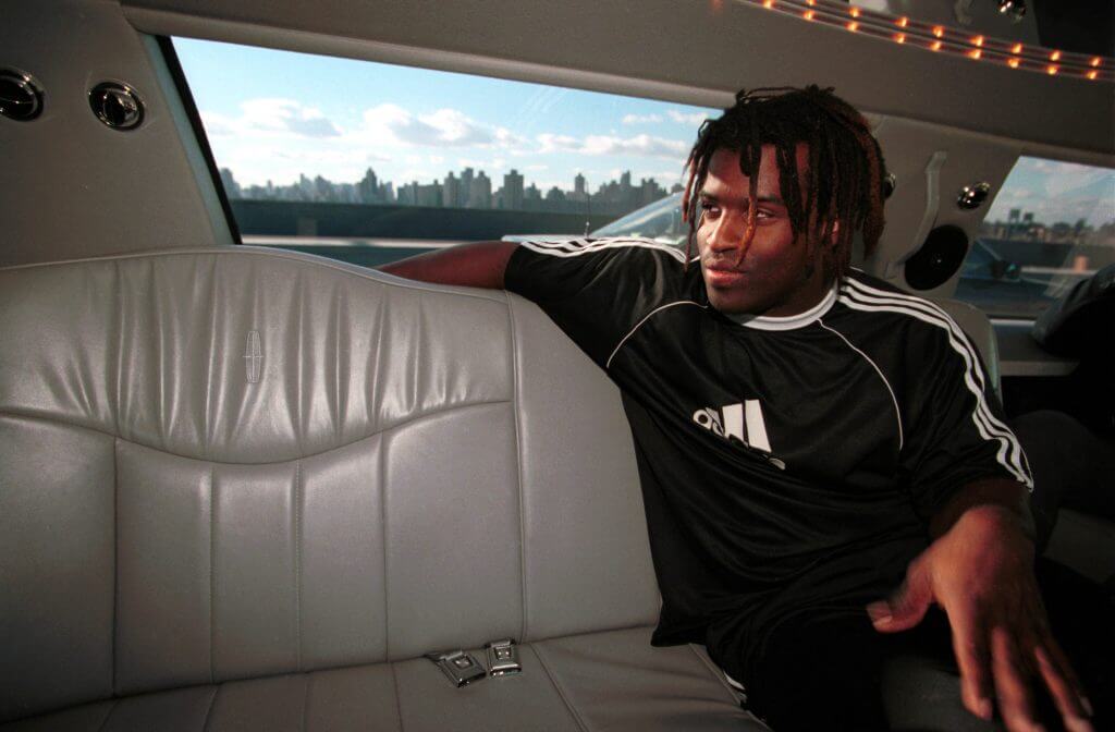 Ricky Williams puts his arm over the backseat of a limo and looks out the window with the New York skyline in the background