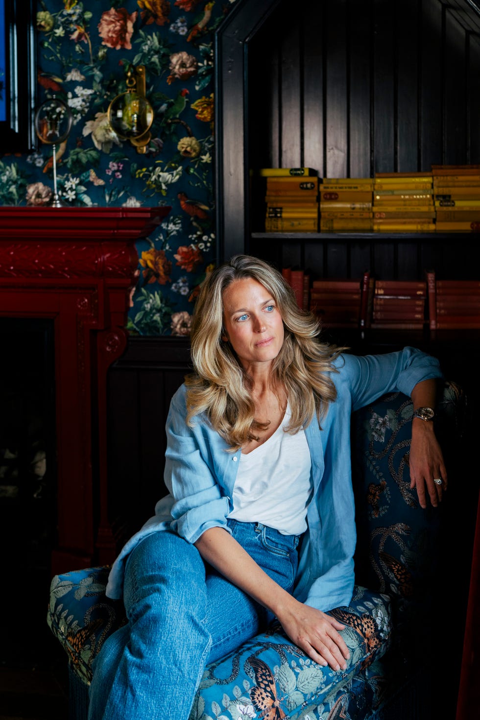 woman seated on a couch in a floralthemed room