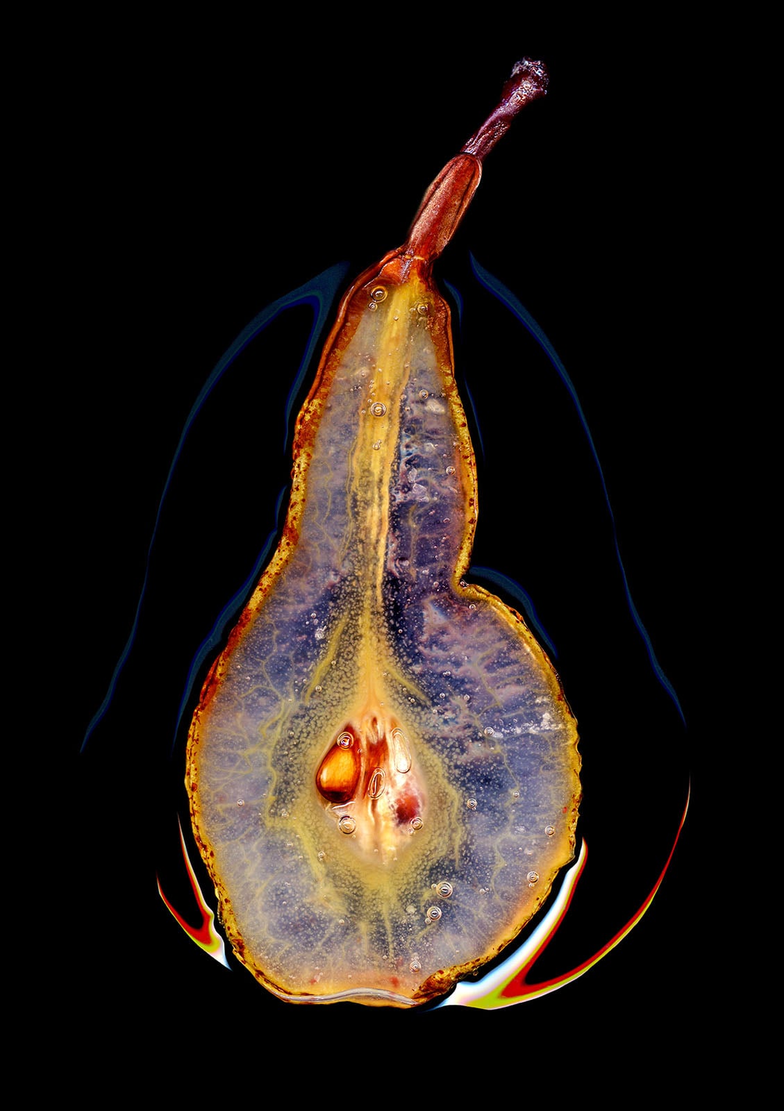 A close-up of a pear sliced in half, showing its seeds and inner texture. The fruit glows with golden yellow and purple hues against a black background, with light reflecting off its moist surface.