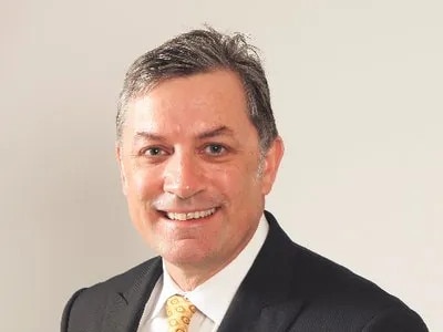 A headshot of a man in suit.