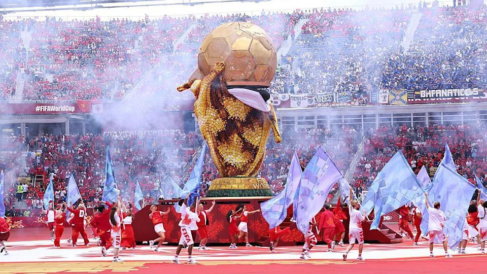 Smoke seen over the golden football and dancers around it
