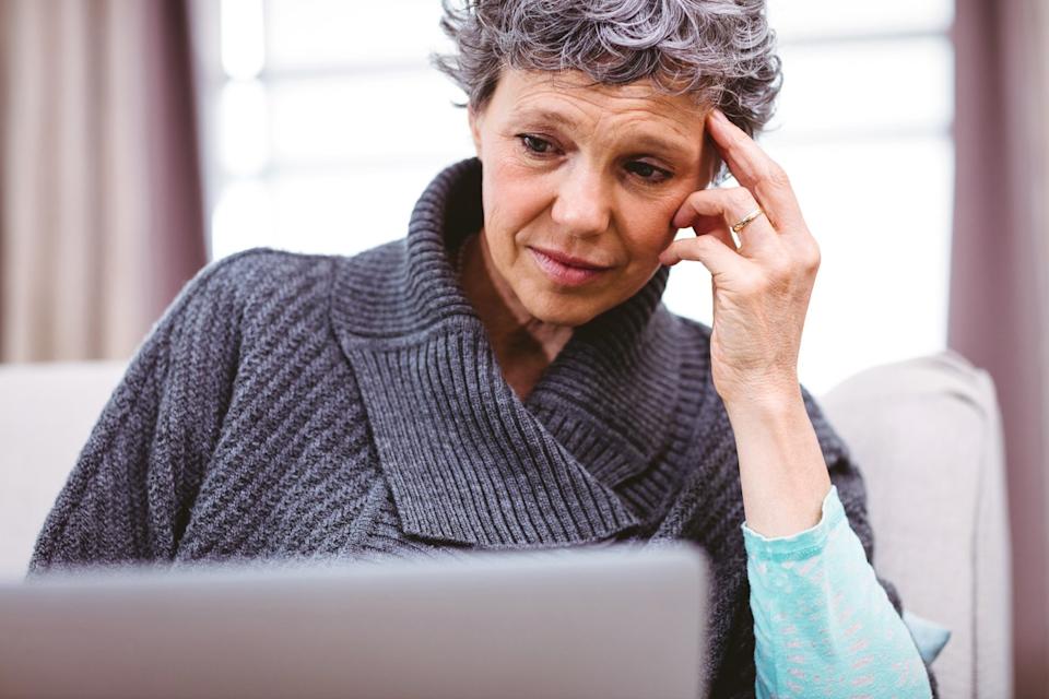 Worried person staring at laptop.