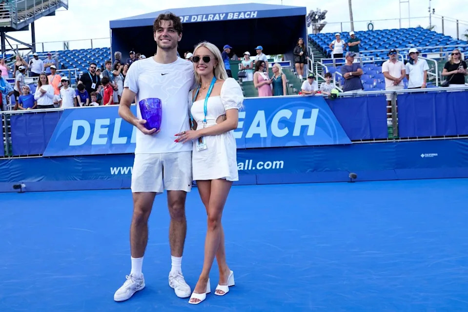 Taylor Fritz, left,holds the trophy as he poses with his girlfriend Morgan Riddle after defeating Miomir Kecmanovic, of Serbia, during the final match at the Delray Beach Open tennis tournament, Sunday, Feb. 19, 2023, in Delray Beach, Fla. AP