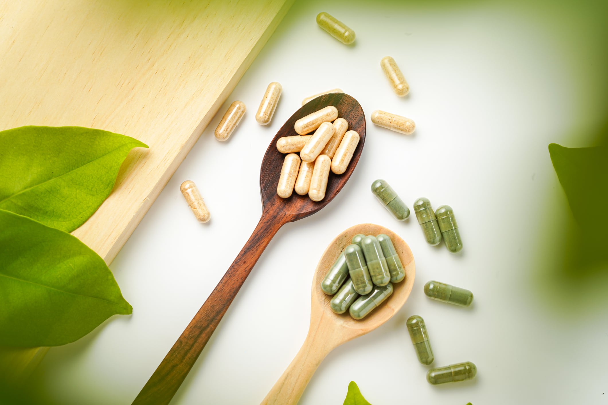 Herbal capsules in wooden spoon, Natural herbs, Alternative Medicine, Herbal supplement