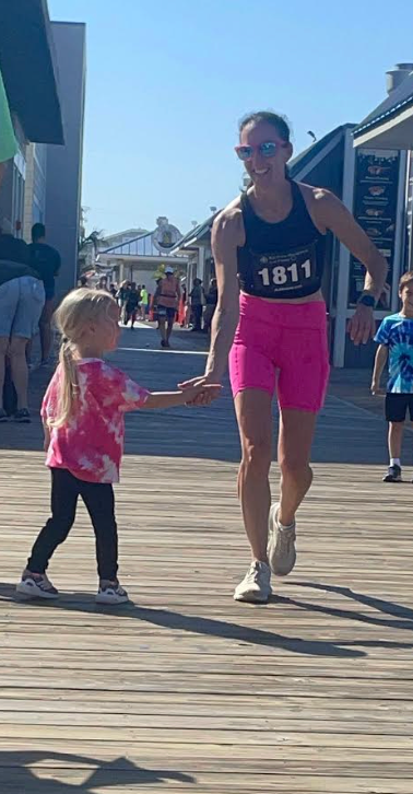The author running a half-marathon nine days after her first chemotherapy treatment, and her daughter giving her a high five on the course.