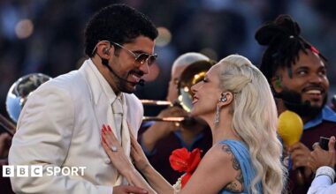 Bad Bunny and Lady Gaga smiling at each other as they perform the half-time show at Super Bowl 60