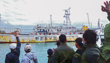 Fishers wave from onboard a Chinese-flagged squid jigger. Credit: Environmental Justice Foundation