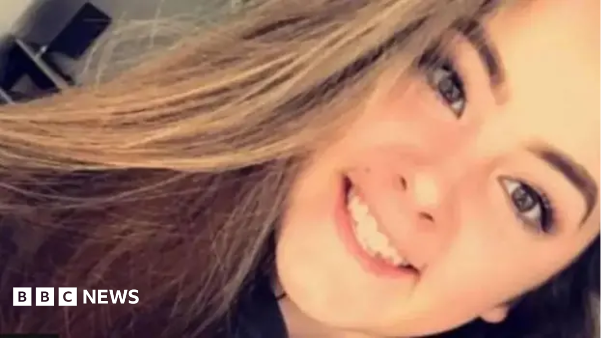 Emily Moore selfie. She is smiling at camera. She has long brown hair.