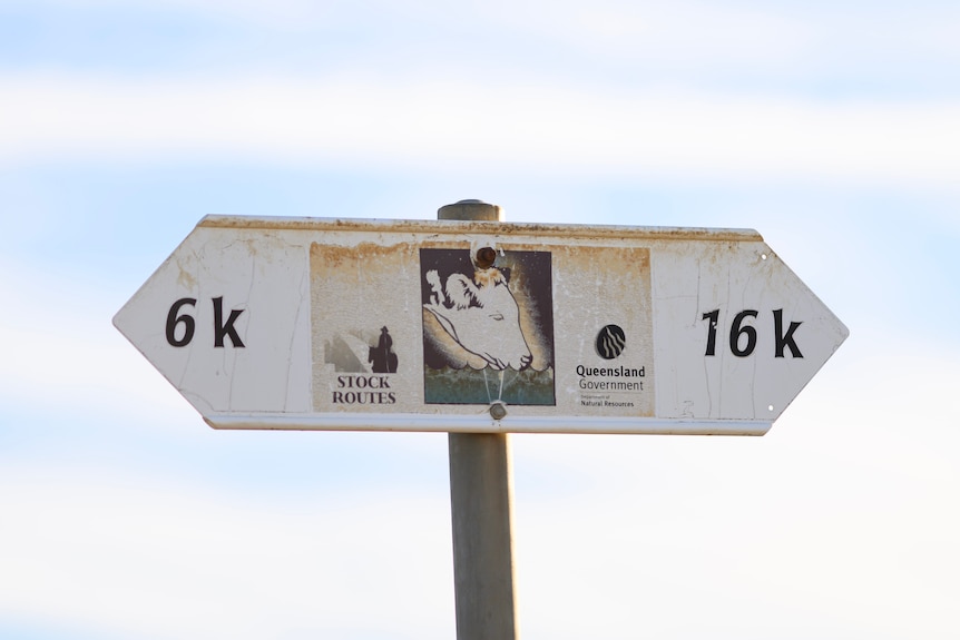 A stock route sign close up wtih 6k and 16k at both triangular ends under a light blue sky.