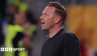 Wales boss Craig Bellamy reacts with an open-mouthed expression as he stands in a round-neck black top