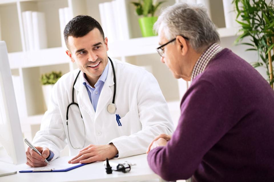 Doctor talking to a patient while making notes.