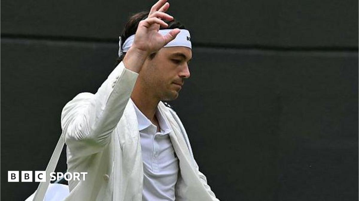 Roger Federer (L) and Russia's Marat Safin (R) enter the court at Wimbledon in 2007