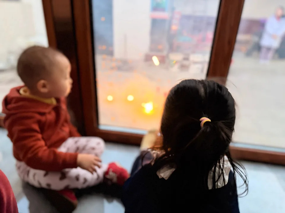 Two cousins sitting by a window in China.