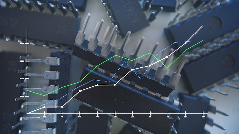 A composite image featuring a blurred background of numerous dark integrated circuit chips with metallic pins. Overlaid on top is a clear line graph with a white Y-axis scaled from 0 to 300,000 and an X-axis labeled with months from JAN to NOV. Three distinct lines plot data: a solid white line, a solid green line, and a dotted blue line, all showing general upward trends over the months.