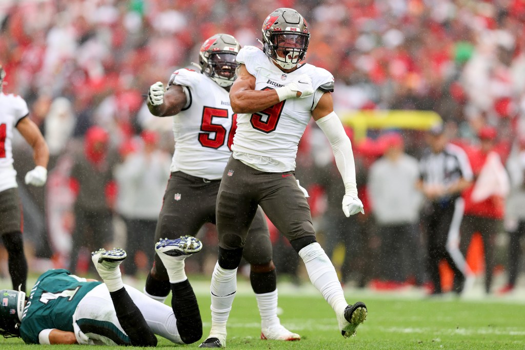 Tampa Bay Buccaneers player Joe Tryon-Shoyinka celebrating after sacking Philadelphia Eagles player Jalen Hurts.