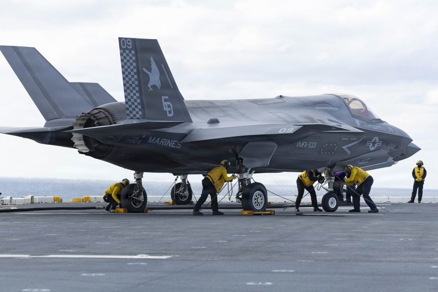 Sailors chock and chain an F-35B Lightning II during deck landing qualifications aboard Wasp class amphibious assault ship USS Kearsarge on May 13, 2026.