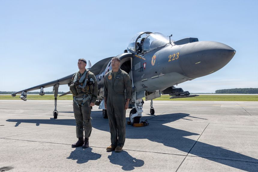 Marine Corps Lt. Col. John B. Cumbie, left, commanding officer of Marine Attack Squadron 223, and Cpl. Myles J. Howard, a fixed-wing aircraft mechanic, stand at attention in front of an AV-8B Harrier II at Marine Corps Air Station Cherry Point, June 3, 2026.