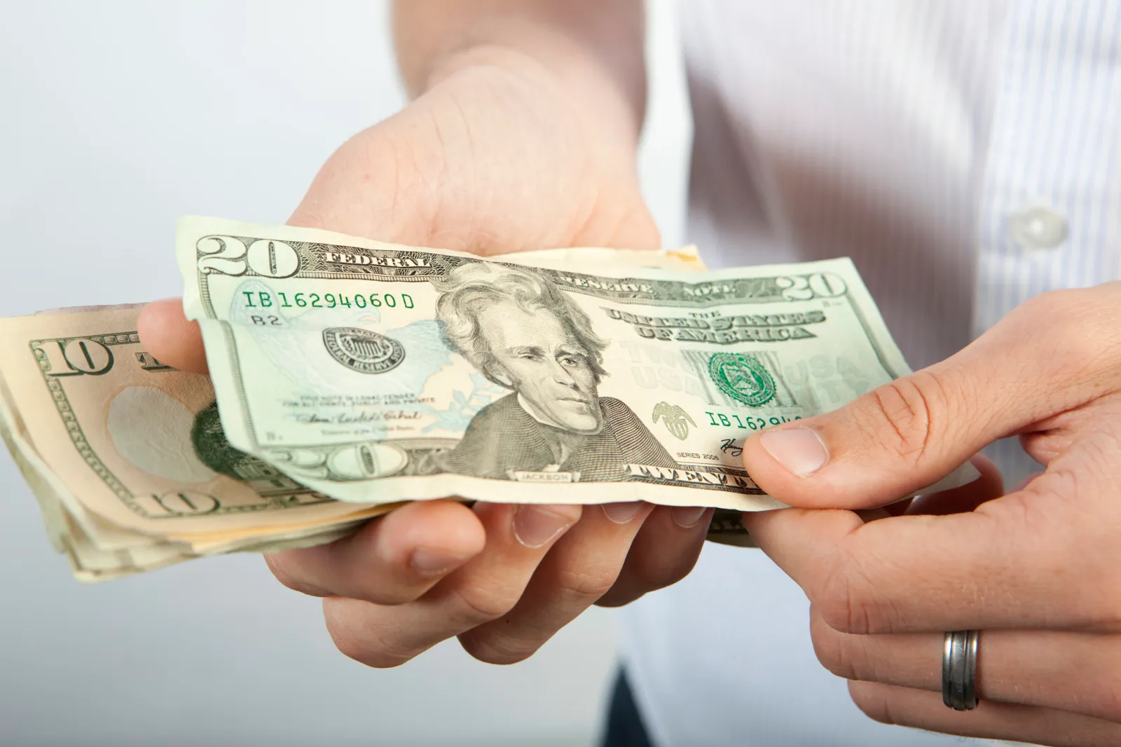 A man is seen counting various denominations of U.S. dollars. (Newscast Limited via AP Images)