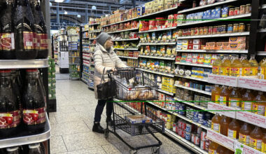 A customer checks prices while shopping at a grocery store in Wheeling, Ill., Friday, Jan. 19, 2024. A typical basket of groceries now costs 20% more than in February 2021, just before inflation began to take off.