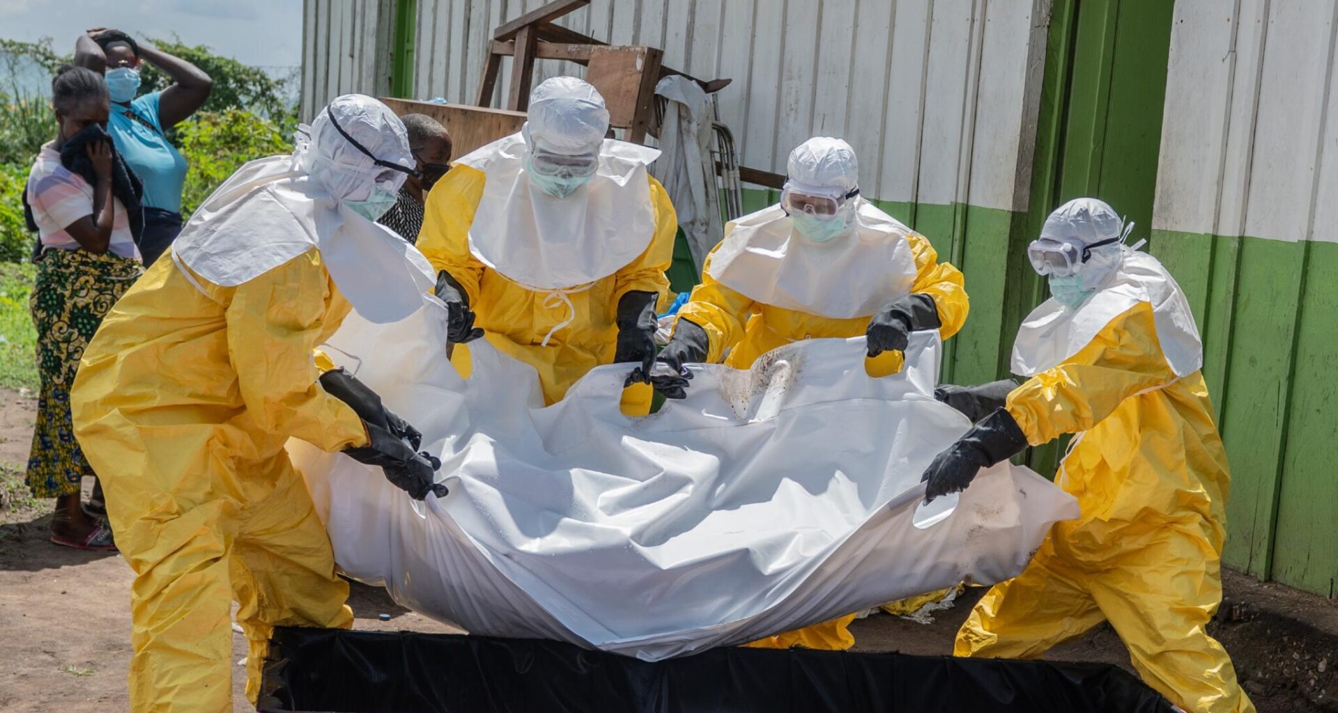 Red Cross workers carry the body of a person who died of Ebola to a coffin at a health center in Rwampara in the Ituri Province of the eastern Democratic Republic of the Congo (DRC) on May 20. (Moses Sawasawa/AP)