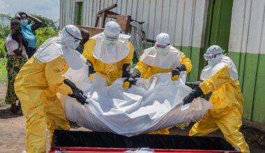 Red Cross workers carry the body of a person who died of Ebola to a coffin at a health center in Rwampara in the Ituri Province of the eastern Democratic Republic of the Congo (DRC) on May 20. (Moses Sawasawa/AP)