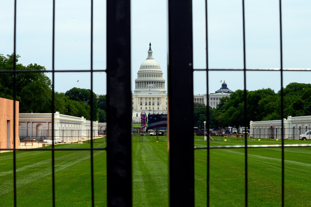 The Capitol is seen through a construction zone security fence as workers continue to build event space for the America 250 celebrations on the National Mall in Washington, Tuesday, June 9, 2026.