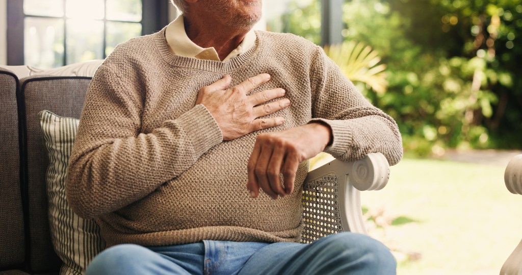 Senior man experiencing chest pain at home.