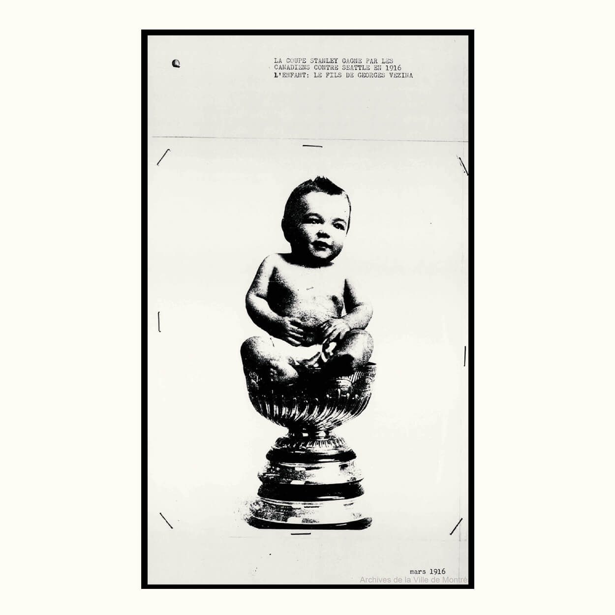 An archival image, taken in 1916, showing the newborn son of legendary goalie Georges Vezina sitting inside the Stanley Cup.