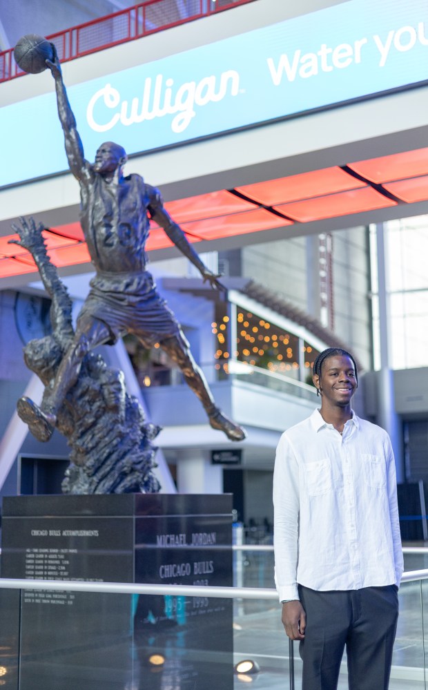 Bulls forward Caleb Wilson stands next to the Michael Jordan statue after an introductory news conference Friday, June 26, 2026, at the United Center. (Josh Boland/Chicago Tribune)