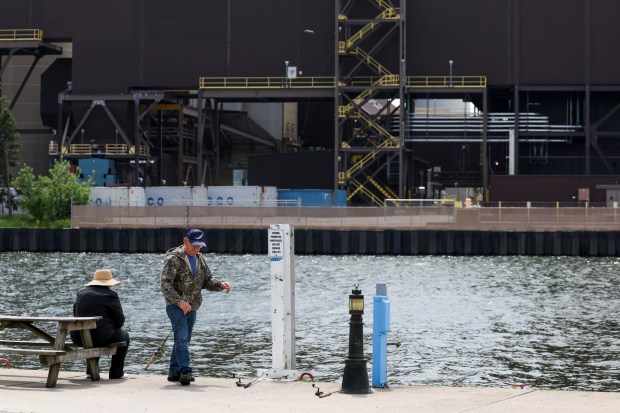 People fish in Trail Creek across from NIPSCO's Michigan City Generating Station near Lake Michigan in Michigan City, Indiana, on May 21, 2026. (Eileen T. Meslar/Chicago Tribune)