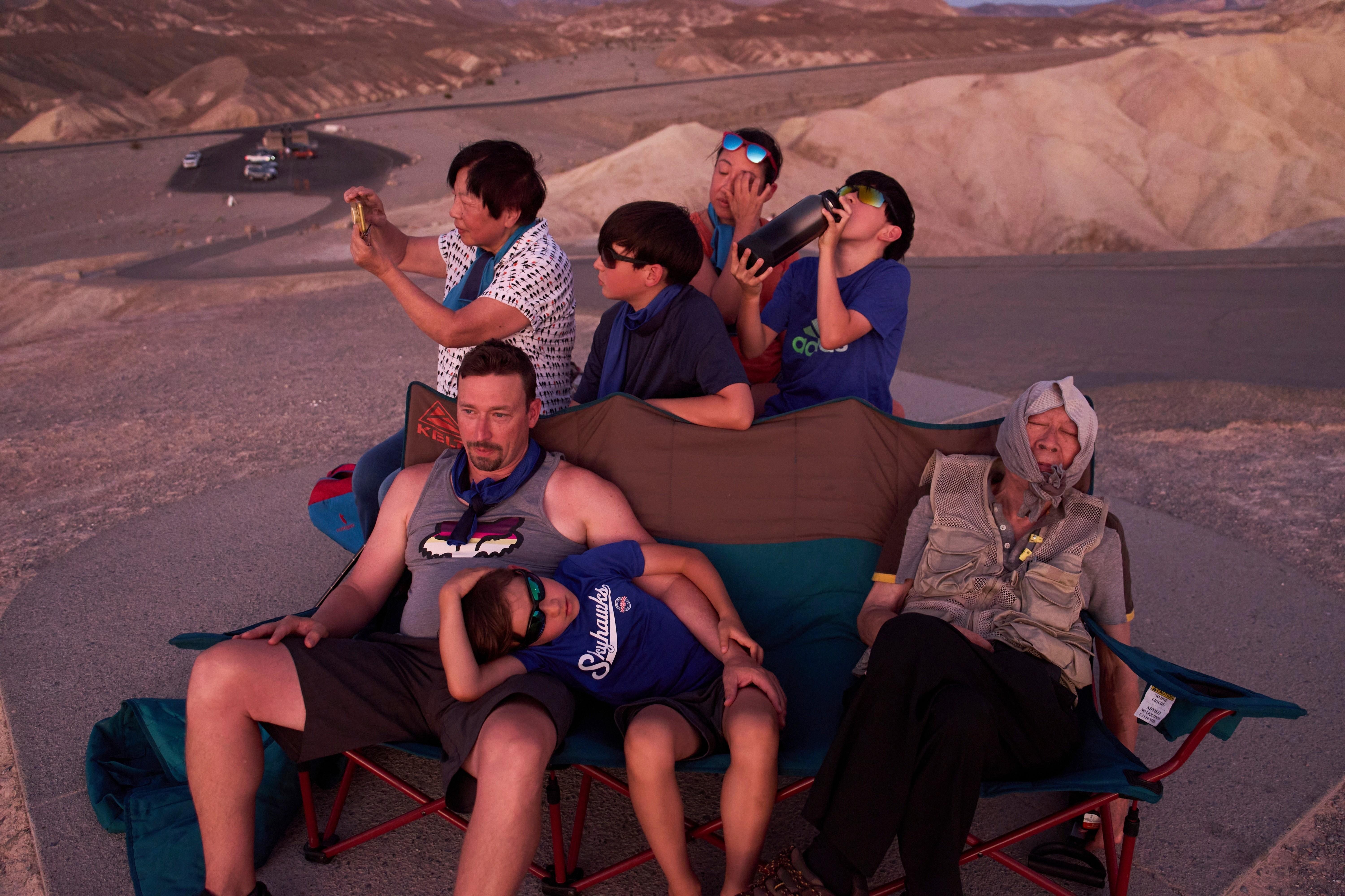 People watch the sunset in the heat at Zabriskie Point in Death Valley National Park.