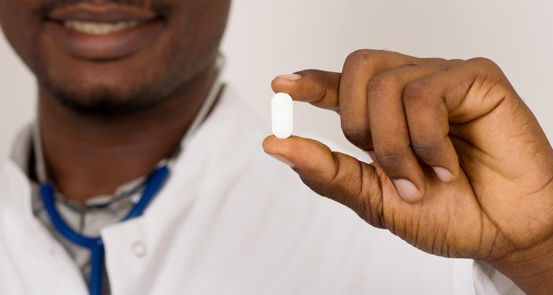 Doctor With Stethoscope Holding White Pill Medicine