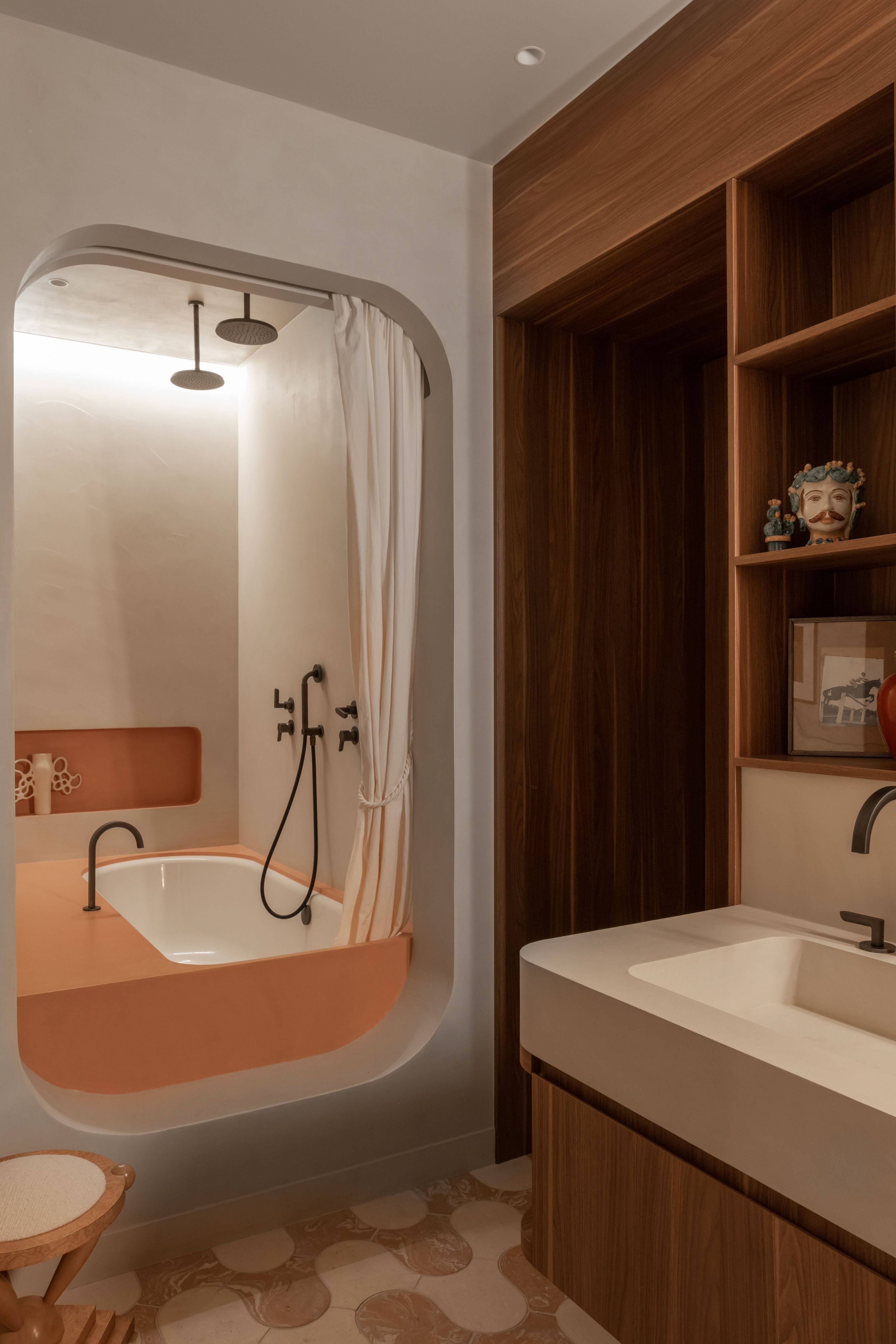 A modern bathroom with a patterned floor, wood accents with a separate zone for the built-in bath with an orange surround and white tub inside