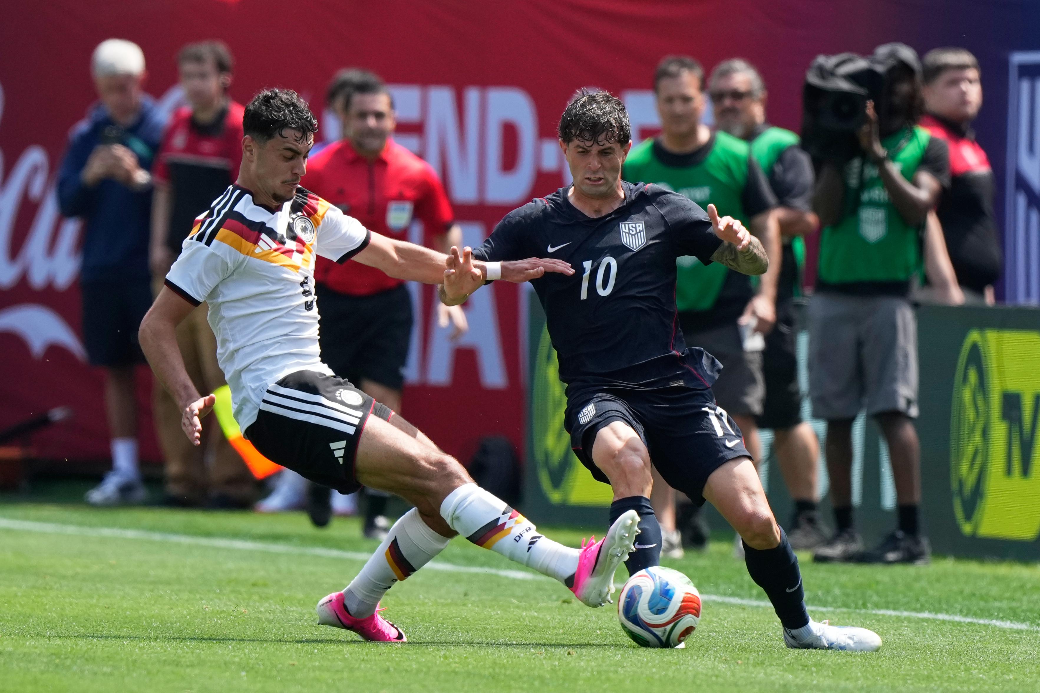 Germany midfielder Aleksandar Pavlović, left, tackles the ball from United...